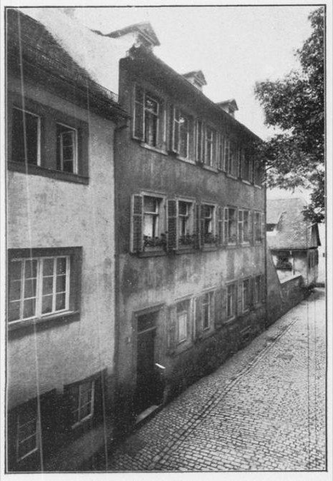 A black and white photograph from 1914 of a tall narrow townhouse on a cobbled street in Würzburg, with shuttered windows and a steep roof.